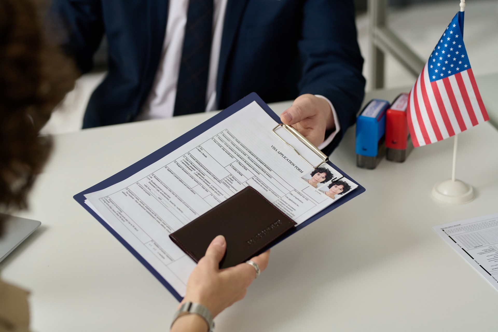 Woman handing visa application in US Immigration office